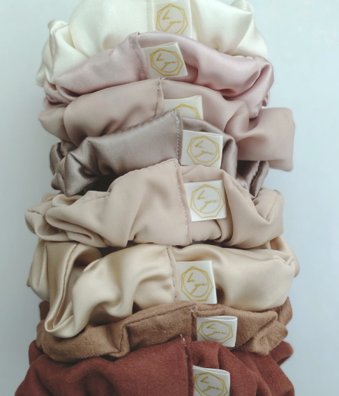 Satin and suede hair scrunchies with Be You logo tags. We offer these in 8 different pink, gold, and nude toned shades